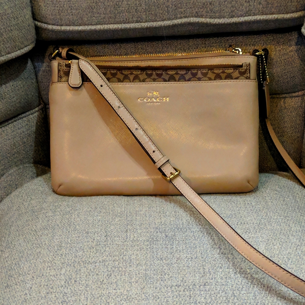 Coach tan crossbody with gold accents and signature pattern zip up case
